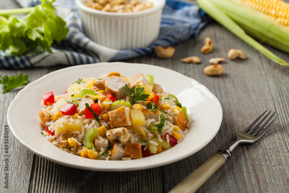 Salad with rice, chicken, peanuts and vegetables. Front view.