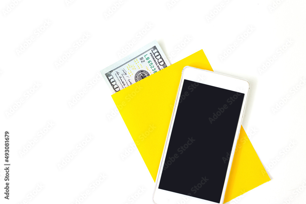 Close up blank yellow a piece of paper, money and empty screen mobile phone on blue background. Close up blank yellow a piece of paper, money and empty screen mobile phone on blue background.