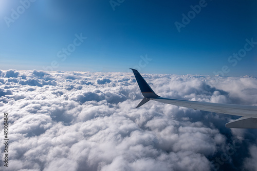 Aircraft wing view from airplane window seat. Beautiful sky and cloud.