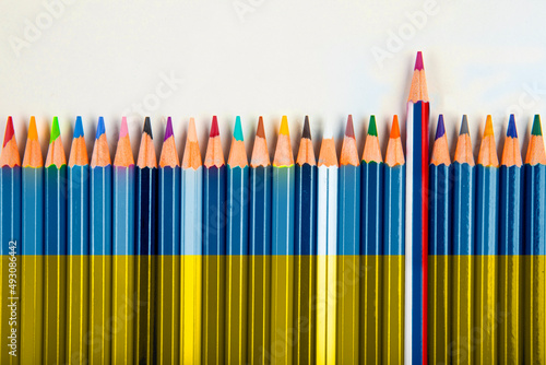 tante matite con i colori  dell'Ucraina (che stanno a rappresentare tutti gli stati del mondo schierati) e una sola matita che emerge con i colori della Russia  photo