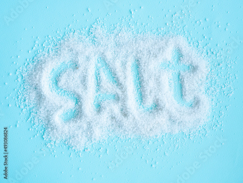 White salt is scattered on blue, the inscription in English salt is scrawled. background image.