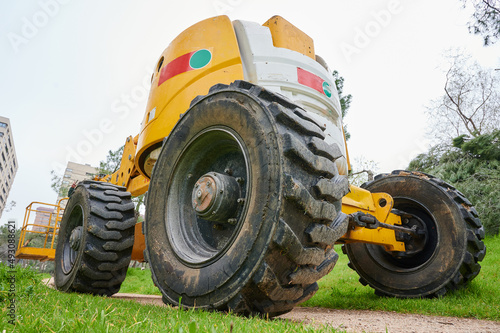 Close-up of the wheels of a crane with hydraulic platform used for lumbering trees of a city park.