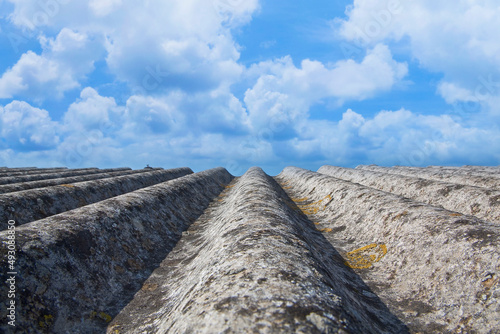 Old aged roof made of corrugated asbestos panels - dangerous materials in buildings and construction industry photo