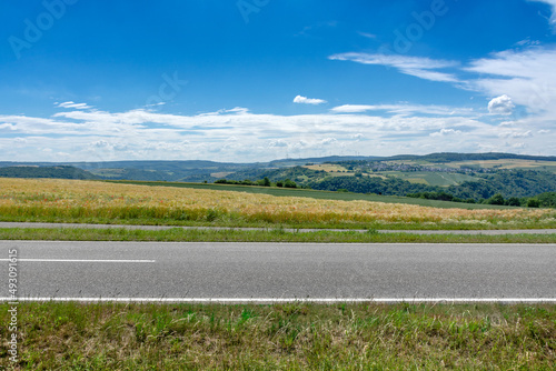 Landstraße durch Felder, Panoramablick auf die Landschaft des Mittelrheintals bei Sankt Goarshausen im Sommer – Country Road in Germany	 photo