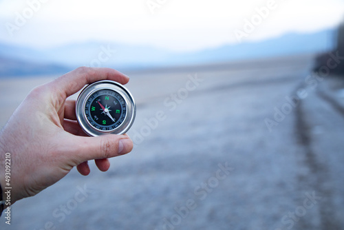 male traveler's hand holding a magnetic compass