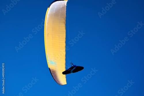 yellow and blue freedom parashute in the sky 