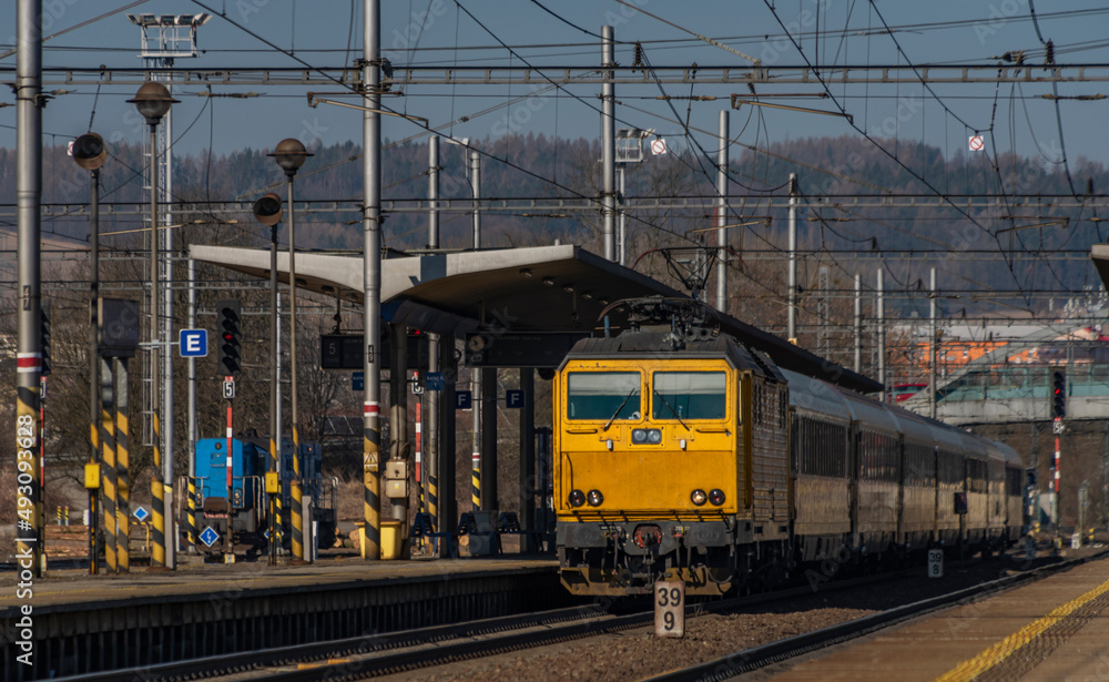 Zabreh station with yellow passenger and cargo trains in sunny day
