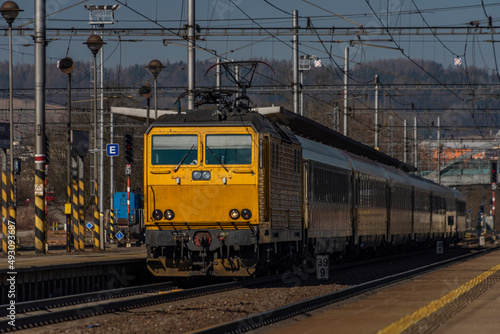 Zabreh station with yellow passenger and cargo trains in sunny day