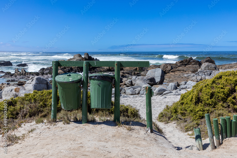 Two green rubbish bins with the ocean behind it. This is in the West Coast National Park in South Africa Two green rubbish bins with the ocean behind it. This is in the West Coast National Park in South Africa