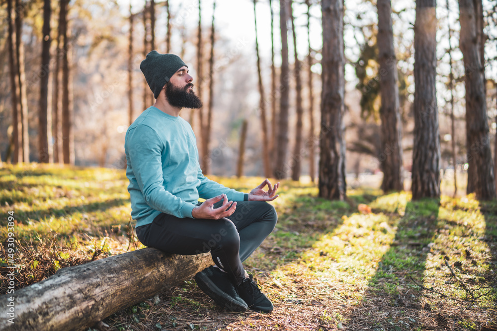 Sporty man enjoys meditating in the nature.