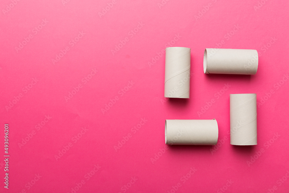 Flat lay composition with empty toilet paper rolls and space for text on color background. Recyclable paper tube with metal plug end made of kraft paper or cardboard Flat lay composition with empty toilet paper rolls and space for text on color background. Recyclable paper tube with metal plug end made of kraft paper or cardboard