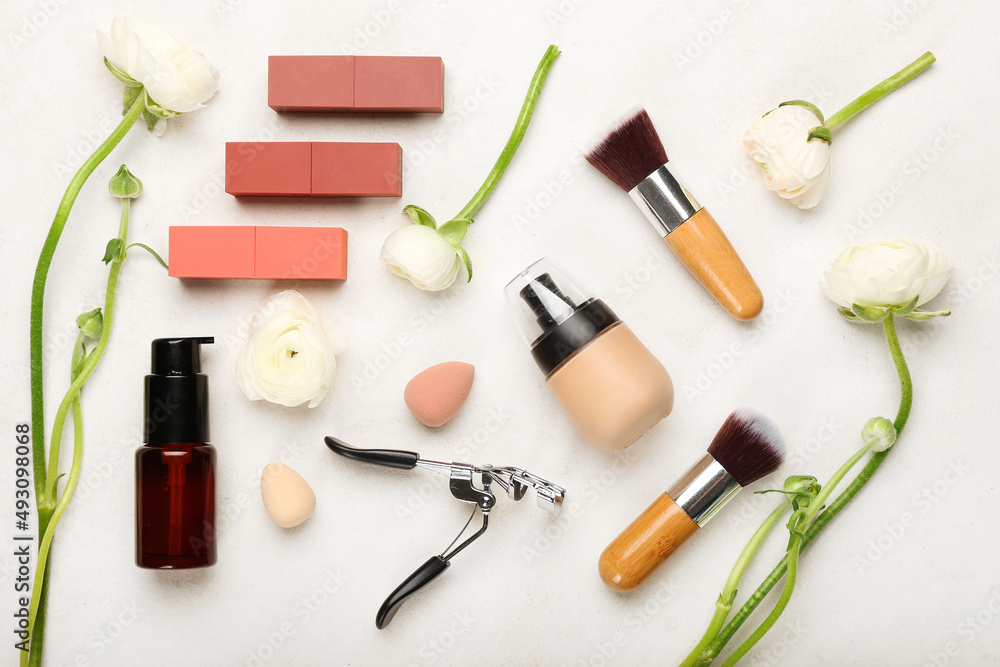 Composition with cosmetic products, supplies and ranunculus flowers on light background Composition with cosmetic products, supplies and ranunculus flowers on light background