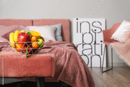 Fruit basket on pink ottoma...