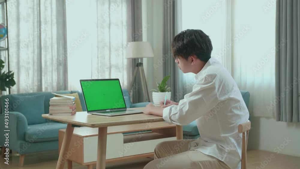 Side View Of Asian Man Student Look At Green Screen Computer And Write In The Notebook While Studying Online At Home
Side View Of Asian Man Student Look At Green Screen Computer And Write In The Notebook While Studying Online At Home