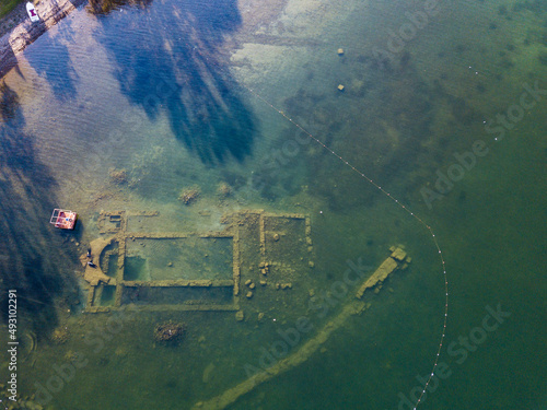 Two divers explore the remains of a church submerged in water photo