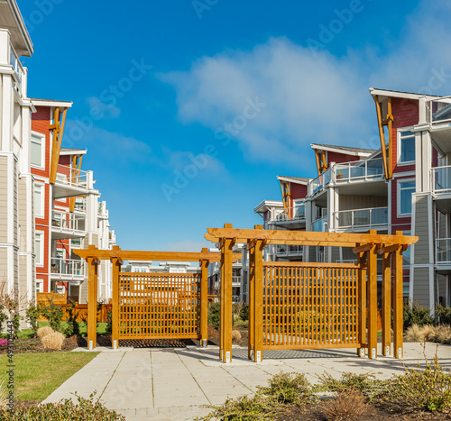 Wooden trellis in new neighborhood modern apartment building complex. Exterior. photo