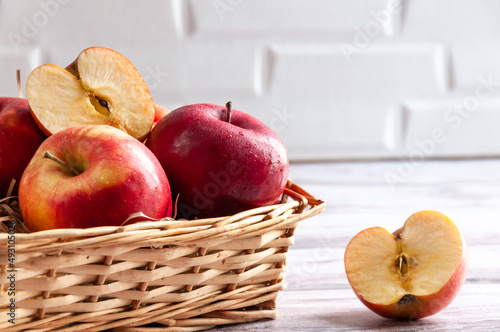 Fresh apples isolated in basket on wooden background under bright sunlight. Fresh natursl product. Harvest of apples. Little basket with harvest of fruit. Spring. Food. Close up photo