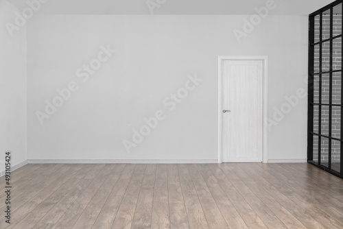 View of big empty room with light wall and door