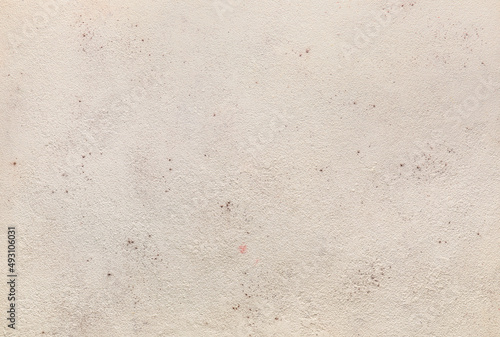 Aged beige stucco wall text...
