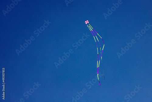 angled view of a colorful kite flying waving