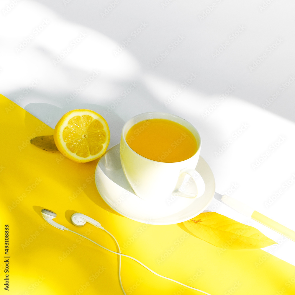 Orange drink in glass cup, on white and yellow background. Orange drink in glass cup, on white and yellow background.