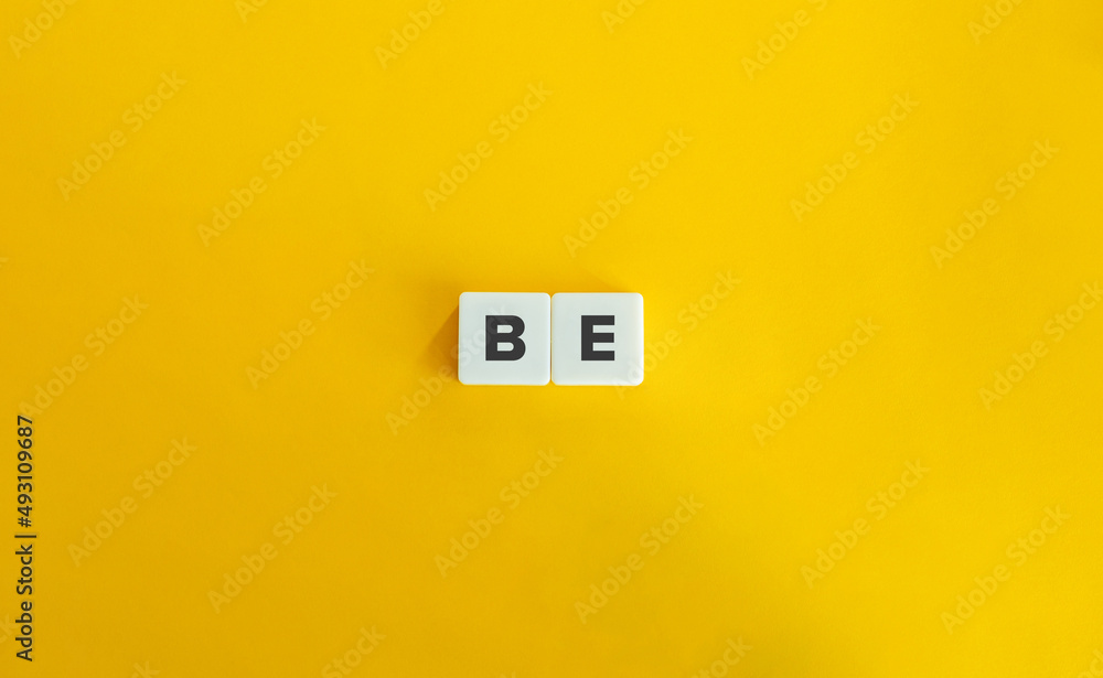 Be Word on Letter Tiles on Yellow Background. Minimal Aesthetics. Be Word on Letter Tiles on Yellow Background. Minimal Aesthetics.