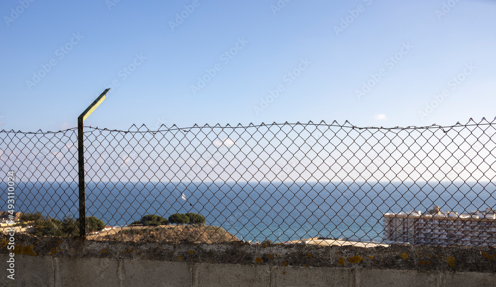Metal mesh, chain-link, against the background of the sea. Metal mesh, chain-link, against the background of the sea.
