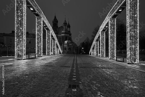 Christmas decorations on the steel structure of the bridge and towers of the Gothic cathedral at night