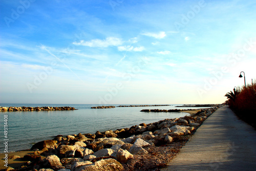 Beautiful promenade near the quiet Adriatic sea surrounded by massive rocks under serene sky with light clouds in Pedaso