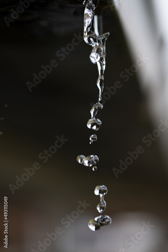 Water flowing out of a gutter drain pipe after a rain storm where the heavens opened up showing the absolute beauty in nature of each individual droplet 