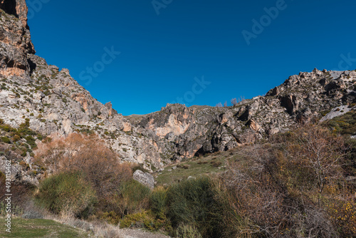 Blue sky over the vertical walls of the mountains on the route of the Monachil river, in Los Cahorros, Granada, Spain.