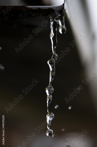 Water flowing out of a gutter drain pipe after a rain storm where the heavens opened up showing the absolute beauty in nature of each individual droplet 