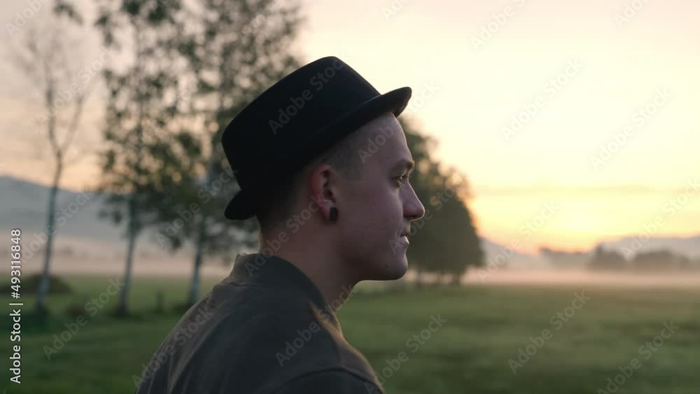 Young Man In Hat Standing Meadow On Misty Morning Young Man In Hat Standing Meadow On Misty Morning