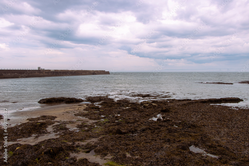 Heugh breakwater pier from shore in stormy, cloudy weather seascape Heugh breakwater pier from shore in stormy, cloudy weather seascape