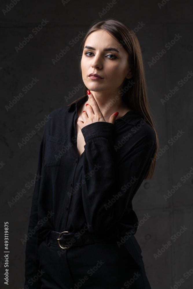 Portrait of a young brunette with long hair in the studio. Dramatic photo in dark colors. Portrait of a young brunette with long hair in the studio. Dramatic photo in dark colors.