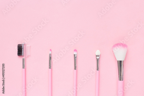 Cute pink makeup brushes on a delicate background. Flat lay, copy space. top view