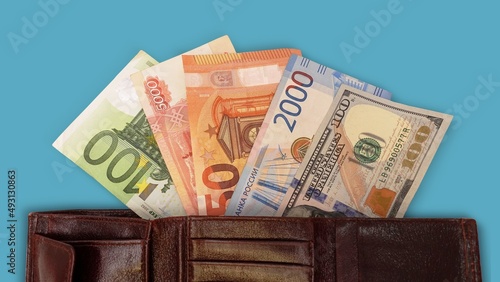 Top view of an open wallet with money. Close-up of a multi-currency wallet. Euro, dollar, ruble banknotes isolated on white background.Cash. The concept of financial literacy and savers