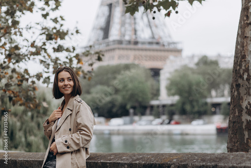 Woman dressed in coat walking on the famous square with great view on the Eiffel tower early in the morning in Paris