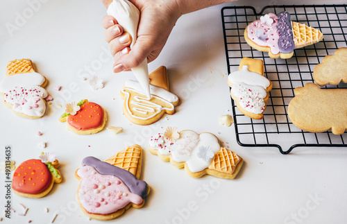 Slika na platnu Woman squeezing icing cover on cookies from a pastry bag