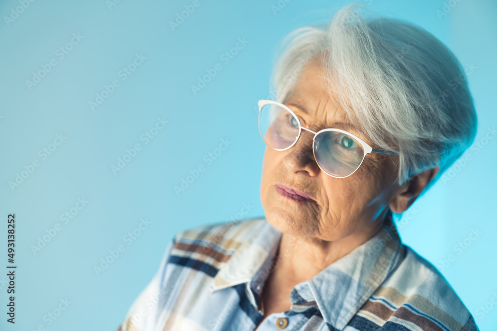 Portrait of elderly worried caucasian grandmother with glasses on her nose. Lonely retirement concept. High quality photo
