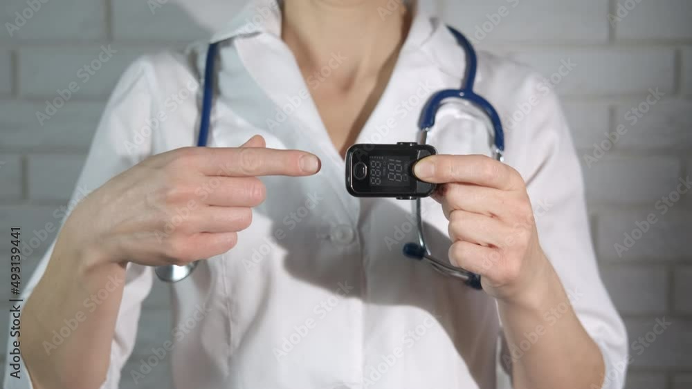Portable oximeter on medic finger. A medical worker show a portable pulse oximeter for patients with lungs problems. Portable oximeter on medic finger. A medical worker show a portable pulse oximeter for patients with lungs problems.