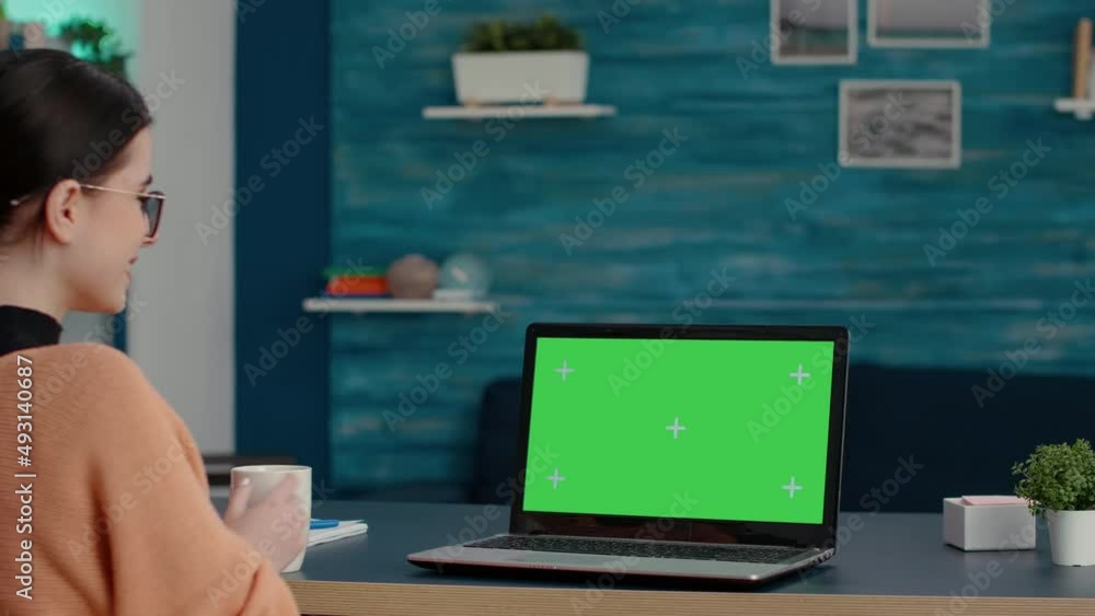 Young student looking at green screen on laptop computer, studying for online class lesson at home. Woman using isolated template with blank chroma key and mockup copy space on computer. Young student looking at green screen on laptop computer, studying for online class lesson at home. Woman using isolated template with blank chroma key and mockup copy space on computer.