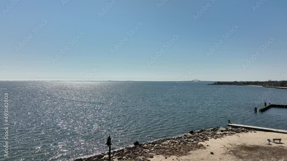 A drone view of the Great South Bay on Long Island, NY near Bay Shore, NY on a sunny day. The drone camera looking out towards the water, boom up slowly. A drone view of the Great South Bay on Long Island, NY near Bay Shore, NY on a sunny day. The drone camera looking out towards the water, boom up slowly.