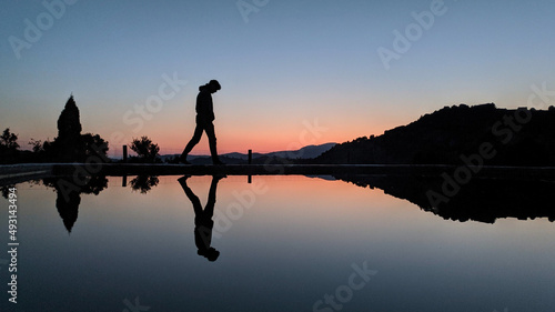 Silhouette of a person on the lake during the sunset
