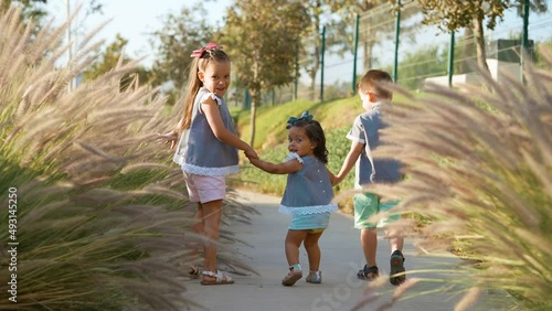 Niños Felices amigos hermanos amistad caminando juntos tomados de la mano disfrutando y divertidos jugando en el parque