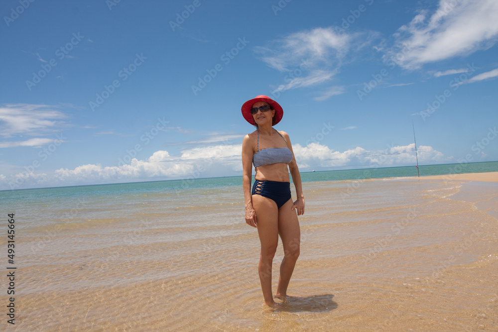 Lady at the beach standing on a sandbar at low tide in Ponta do Corumbau, Brazil Lady at the beach standing on a sandbar at low tide in Ponta do Corumbau, Brazil