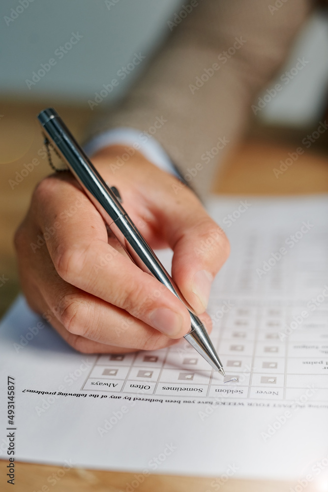 Checking all the appropriate boxes. Closeup shot of a man filling out a medical questionnaire. Checking all the appropriate boxes. Closeup shot of a man filling out a medical questionnaire.