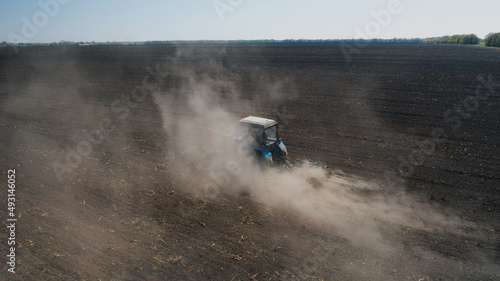 Farming: a farmer on a tractor works the field before sowing