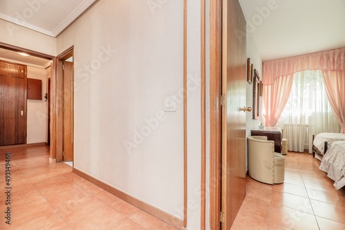 Distributor corridor of a residential house with a room with pink curtains and white curtains