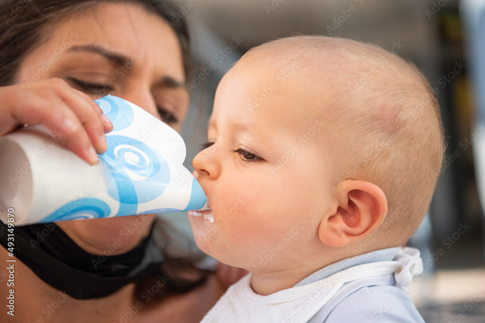 Caucasian boy drinking a milkshake given to him by his mother.
Caucasian boy drinking a milkshake given to him by his mother.